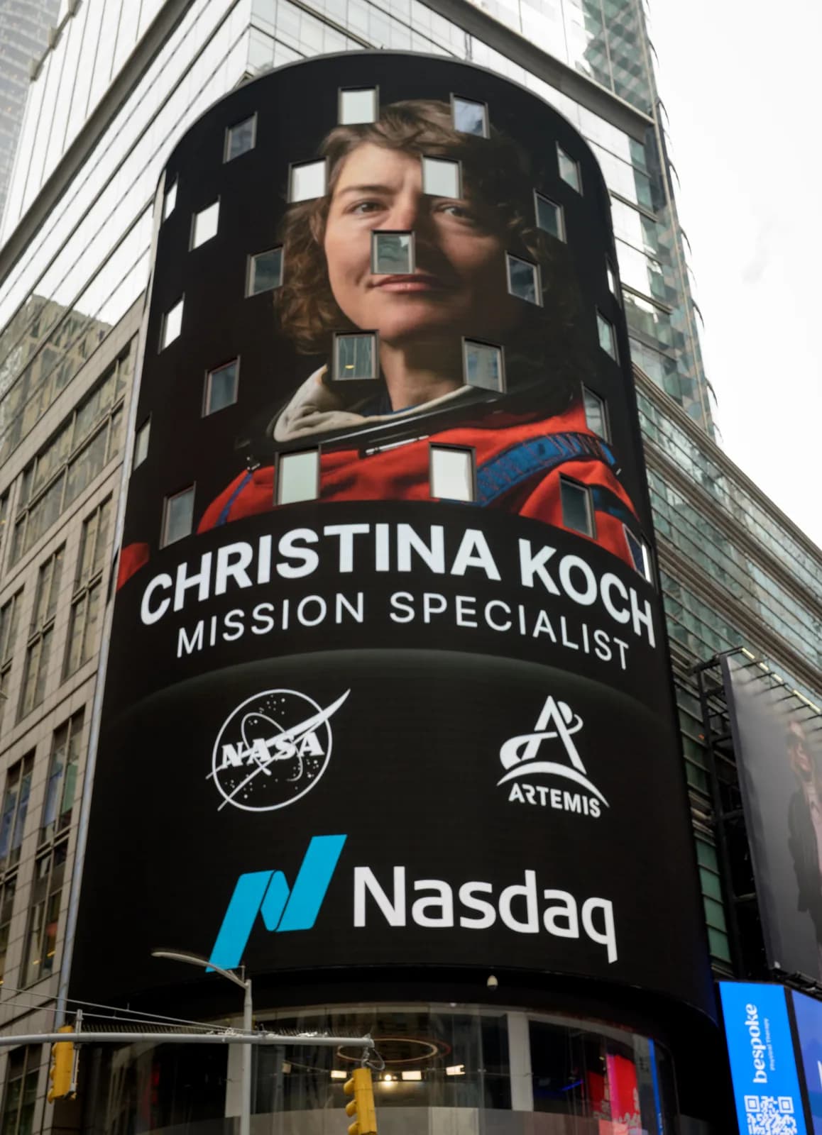 The curved Nasdaq Tower screen at Times Square showing a full-height portrait